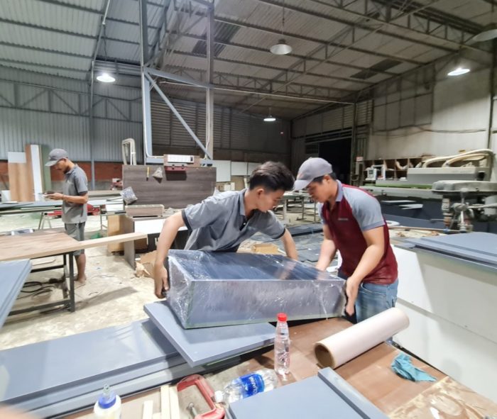 Nhân viên xưởng gỗ phối hợp làm việc cùng nhau