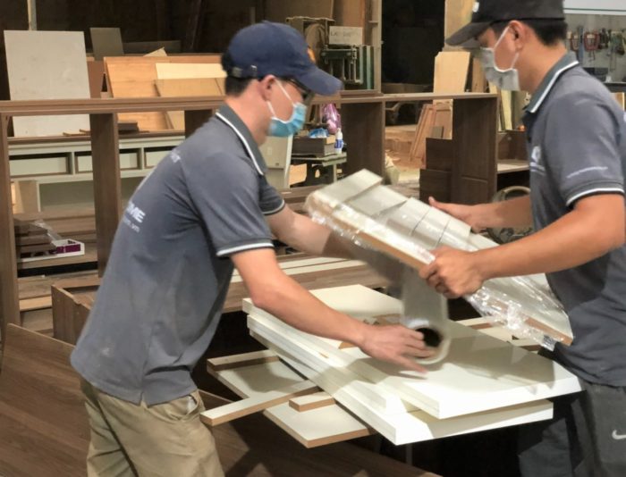 Nhân viên xưởng gỗ phối hợp làm việc hiệu quả